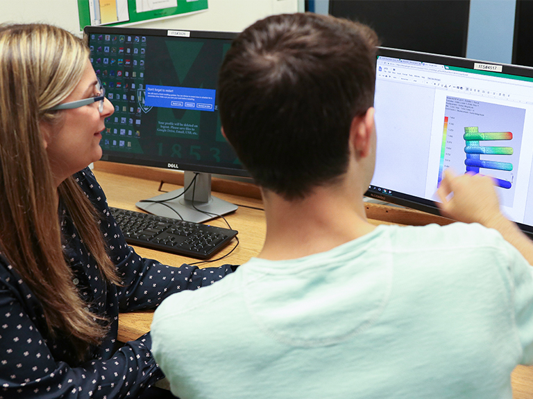 Students in the classroom watch a presentation on mechanical engineering.