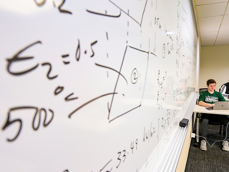 Mathematics lecture to a classroom full of students. 