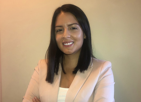 woman with dark hair folding arms over chest smiling 